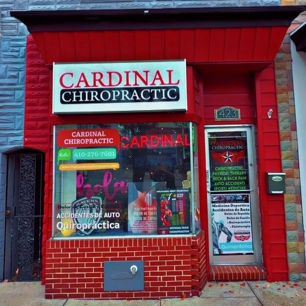 Exterior storefront of Cardinal Chiropractic with red building, window display, and side door, located at 423.