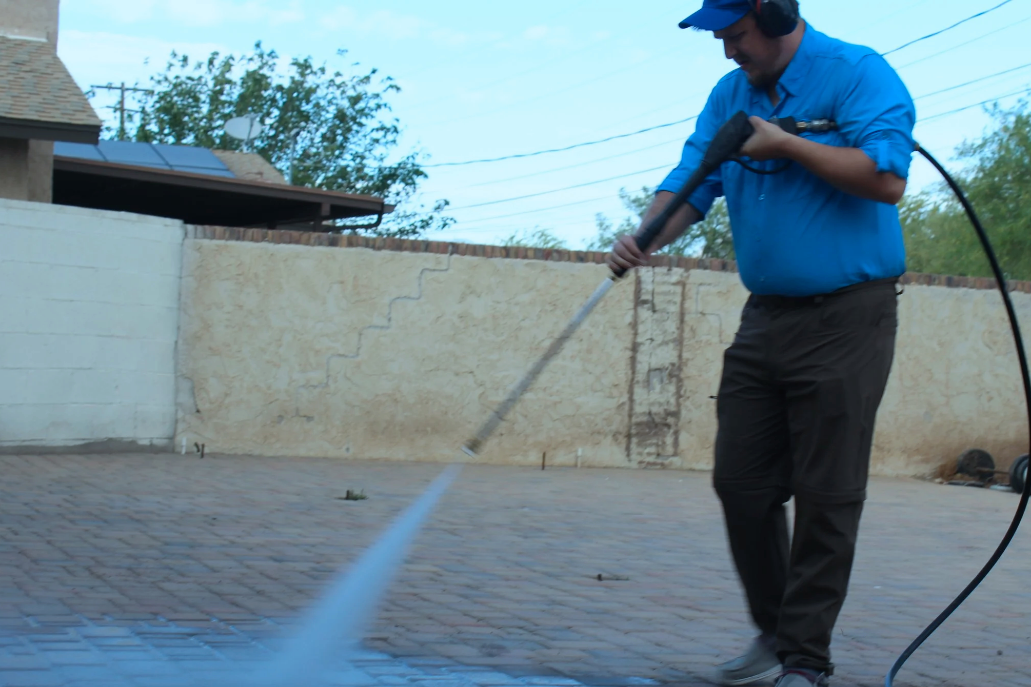 Man pressure washing a paved Patio