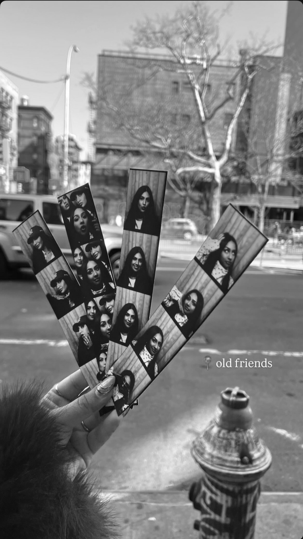 Printed black-and-white photostrips held up as a keepsake