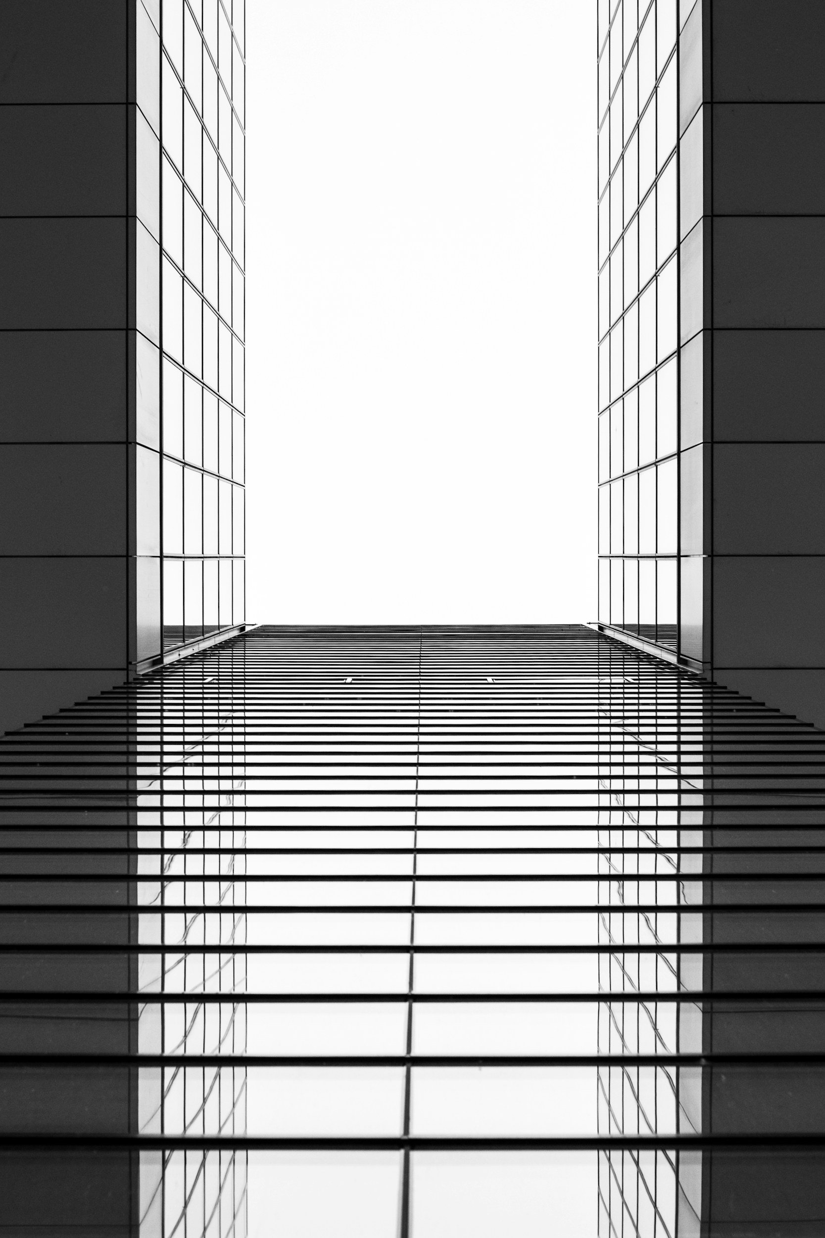 View of two modern glass skyscrapers from below, looking up at the sky.