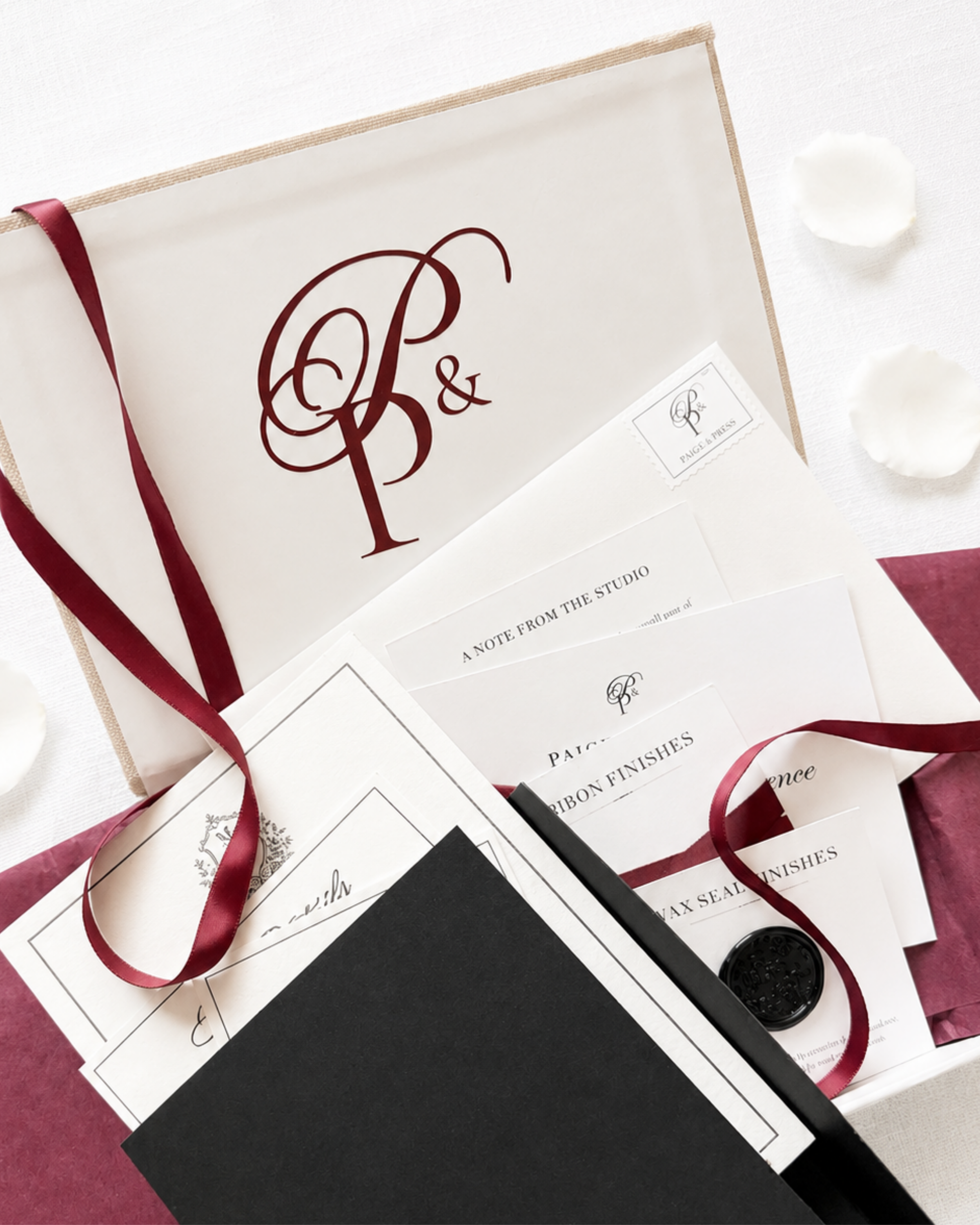 Paige & Press Sample Experience luxury wedding invitation sample box by Paige & Press featuring premium papers, burgundy ribbon, and heirloom stationery.