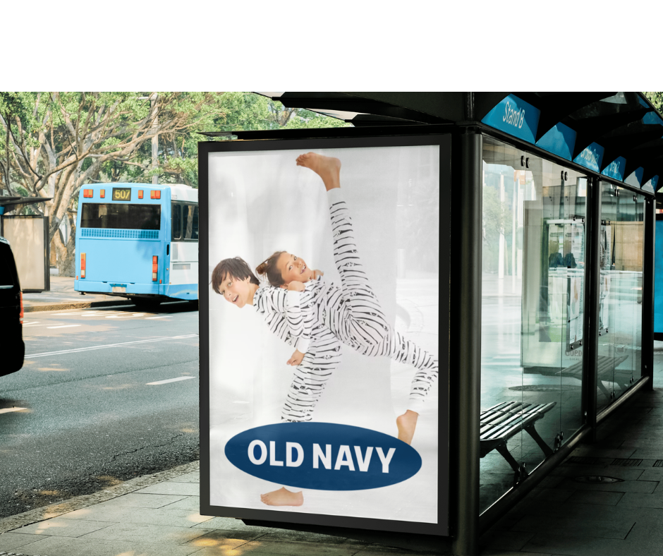 Advertising display at a bus stop featuring two children in striped pajamas playing and laughing, with the Old Navy logo at the bottom.