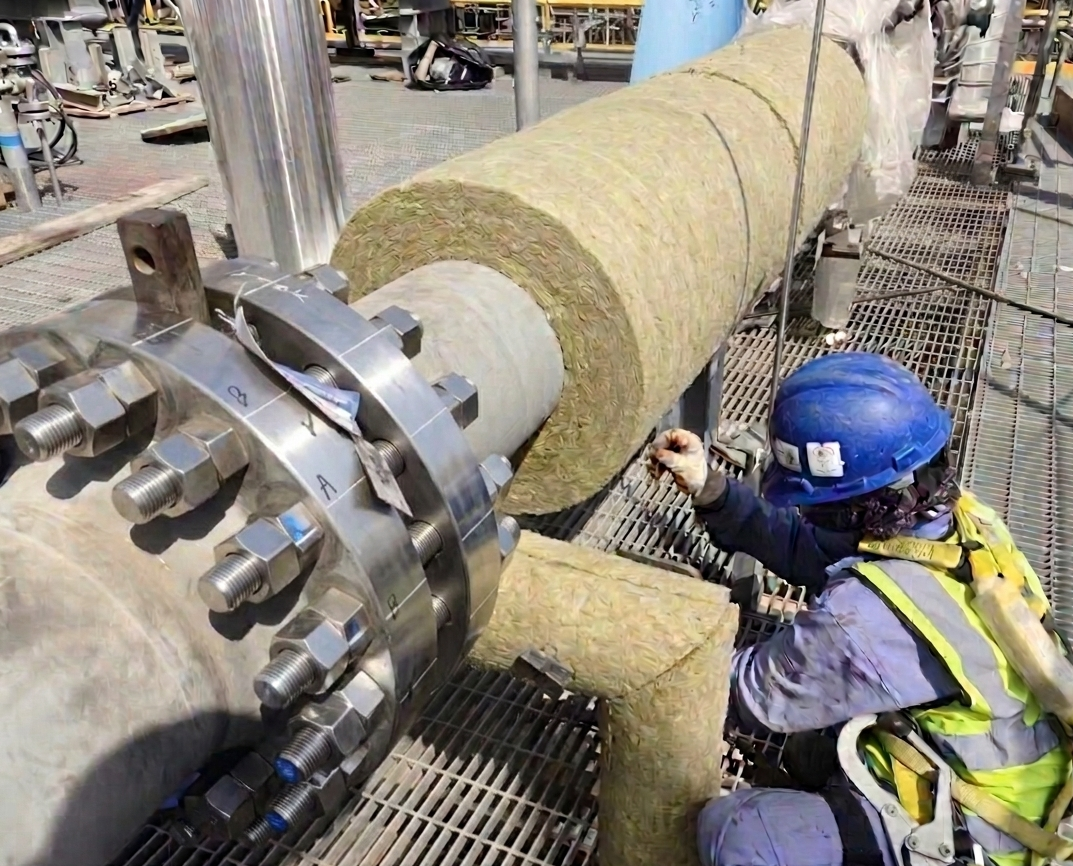 Installation of mineral wool (rockwool) piping insulation for industrial use.