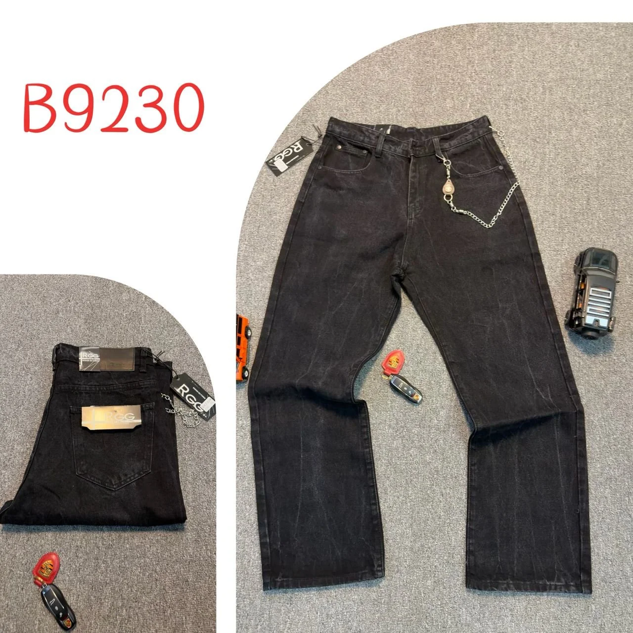 Black jeans with a chain attached to the waist, placed on a gray carpet. Additional items include a remote control, a car key, a small red pouch, a toy truck, and a folded black folder or small bag.