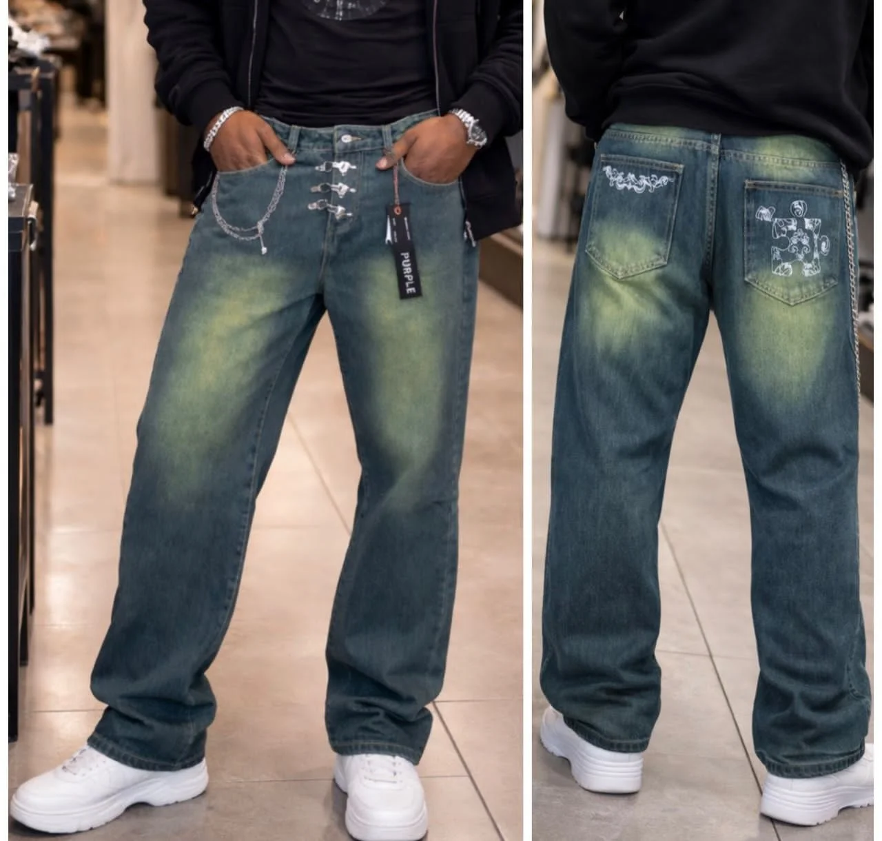 A person wearing baggy, distressed blue jeans with lime green and white fading accents and decorative stitching on the back pockets, paired with white sneakers, in a retail store.