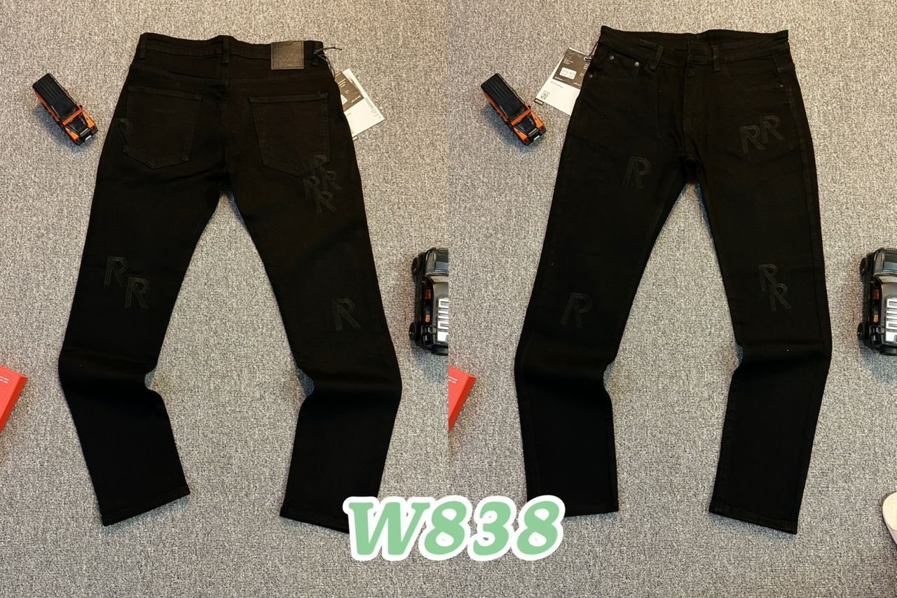 Two pairs of black jeans laid flat on a gray carpeted surface, with various small tools and accessories around them, labeled W838.