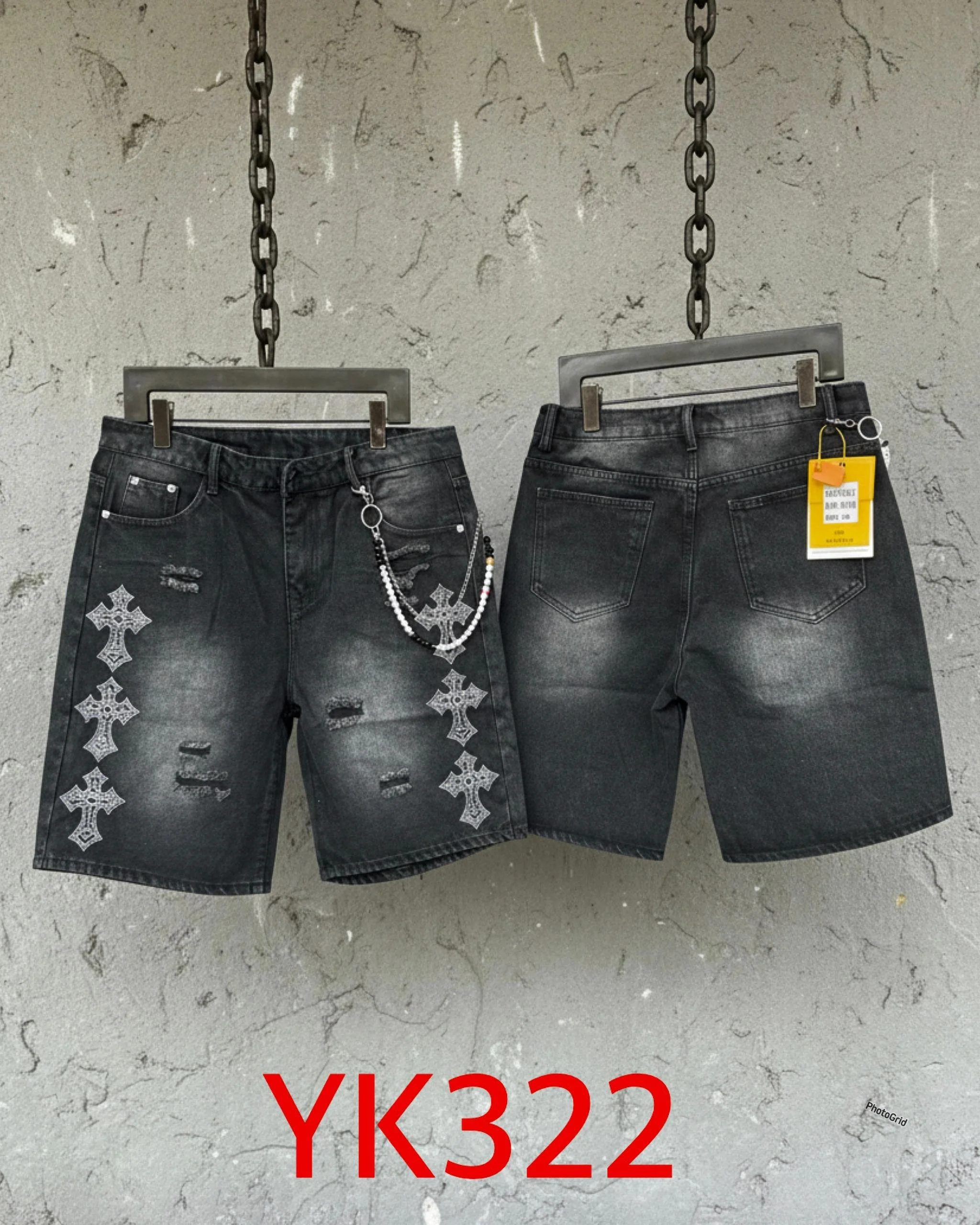 Two pairs of black denim shorts hanging on a wall with chains, one pair has a chain accessory and distressed details, the other pair is plain with a yellow tag. The background is a textured wall, and red text 'YK322' is at the bottom.