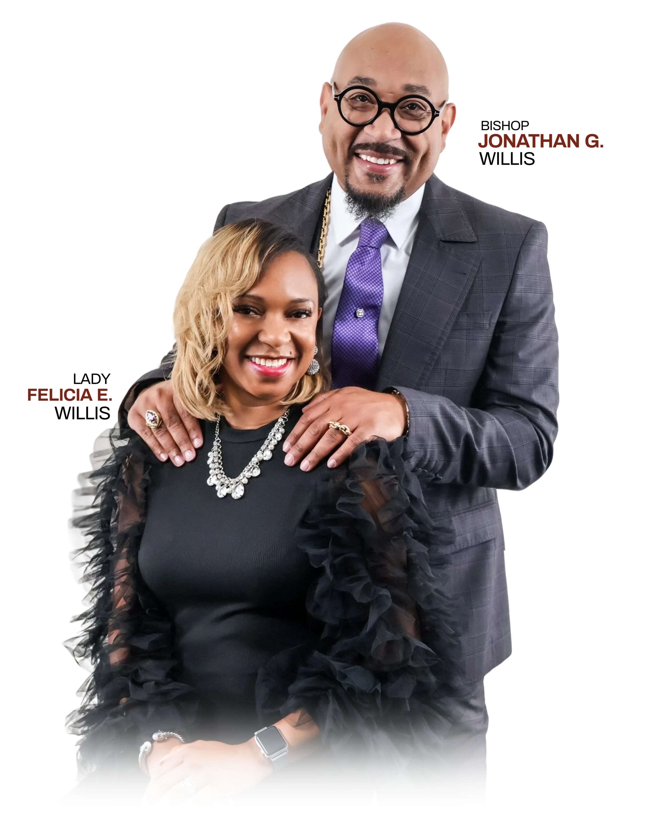 Portrait of a smiling man and woman posing together, with the man wearing glasses and a suit, and the woman with blonde hair adorned with jewelry.