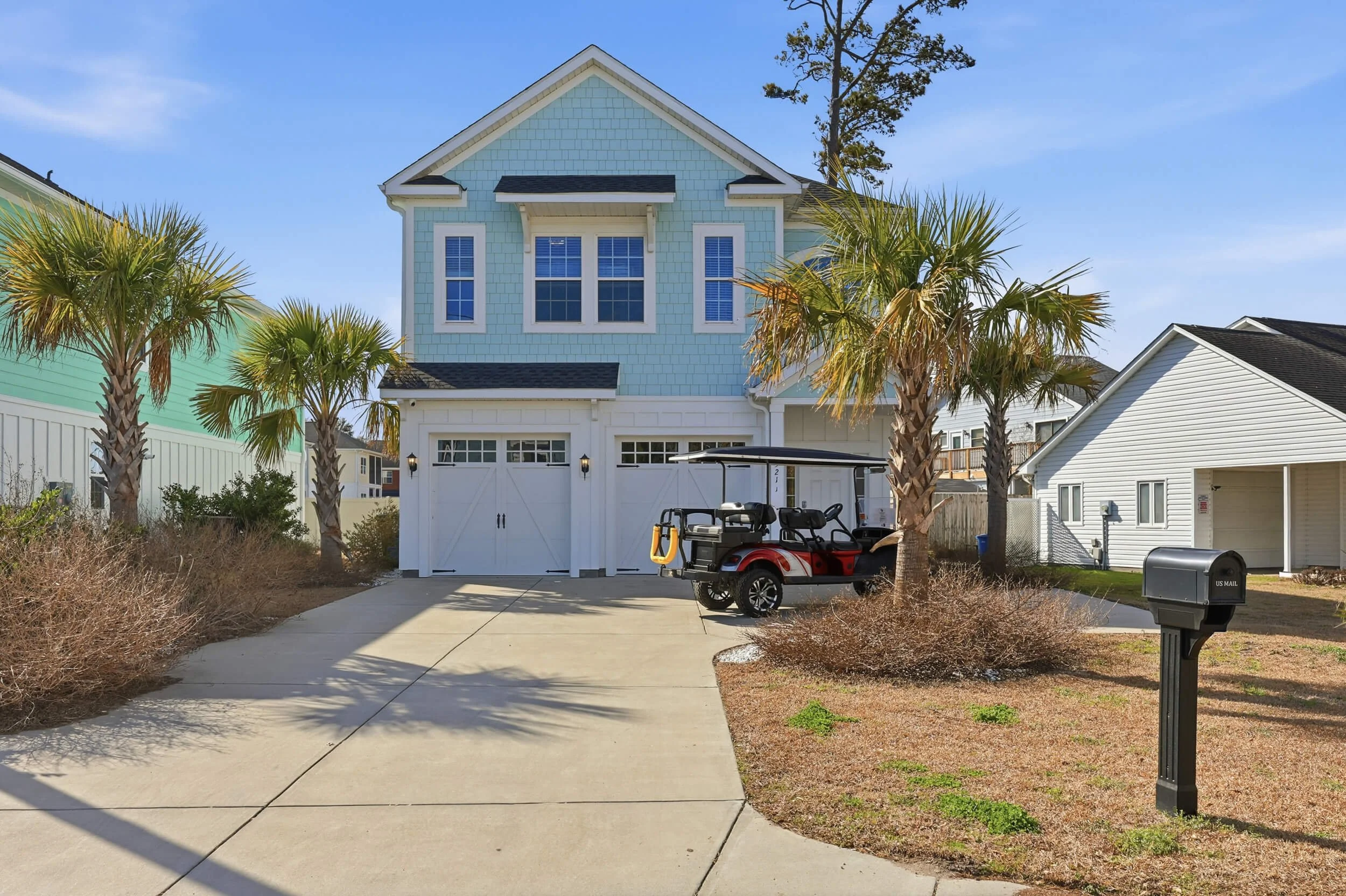 Exterior of a CoHost Works coastal vacation rental with palm trees, a golf cart, and guest-friendly outdoor access near Carolina and Georgia destinations.