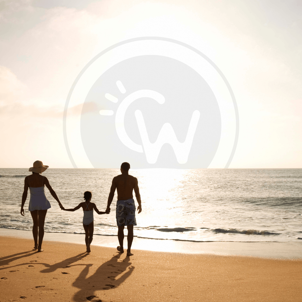 Family walking along the beach at sunset, representing the welcoming coastal stays and guest experiences offered by CoHost Works vacation rentals.