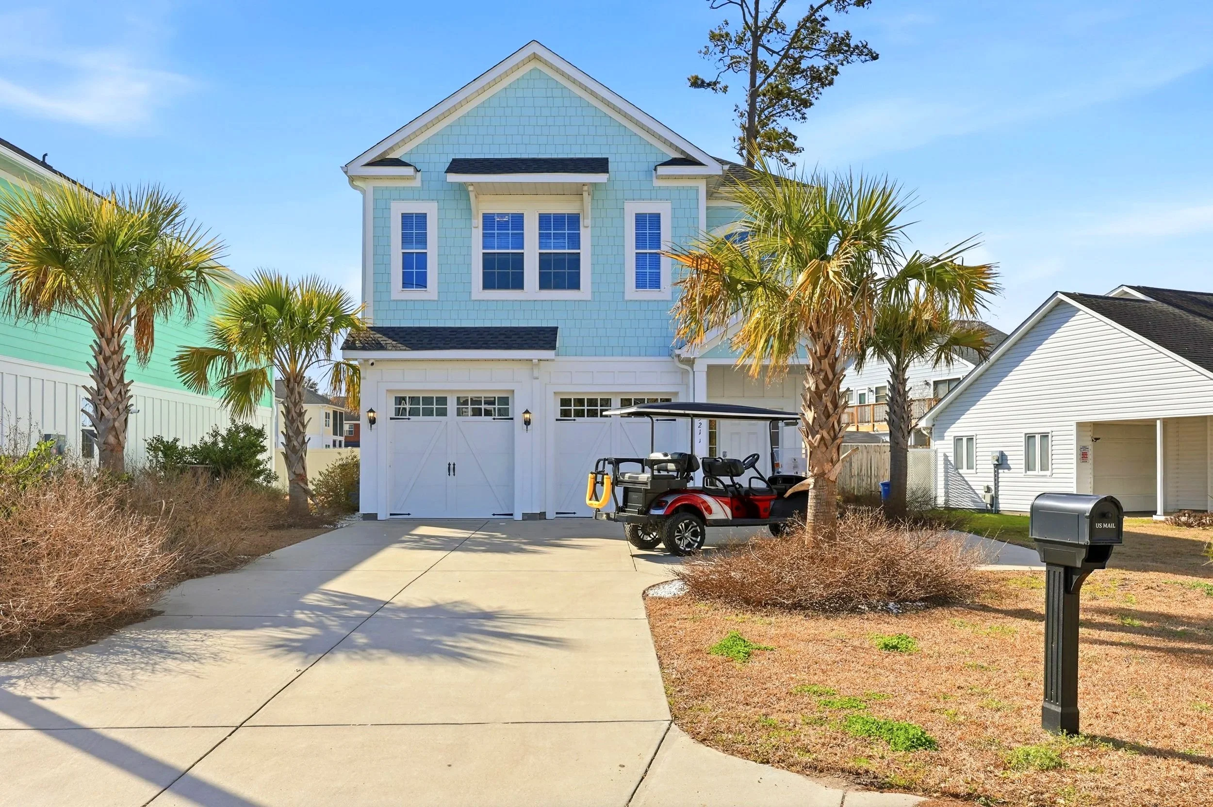 Coastal vacation rental in South Carolina with palm trees and elevated home design.