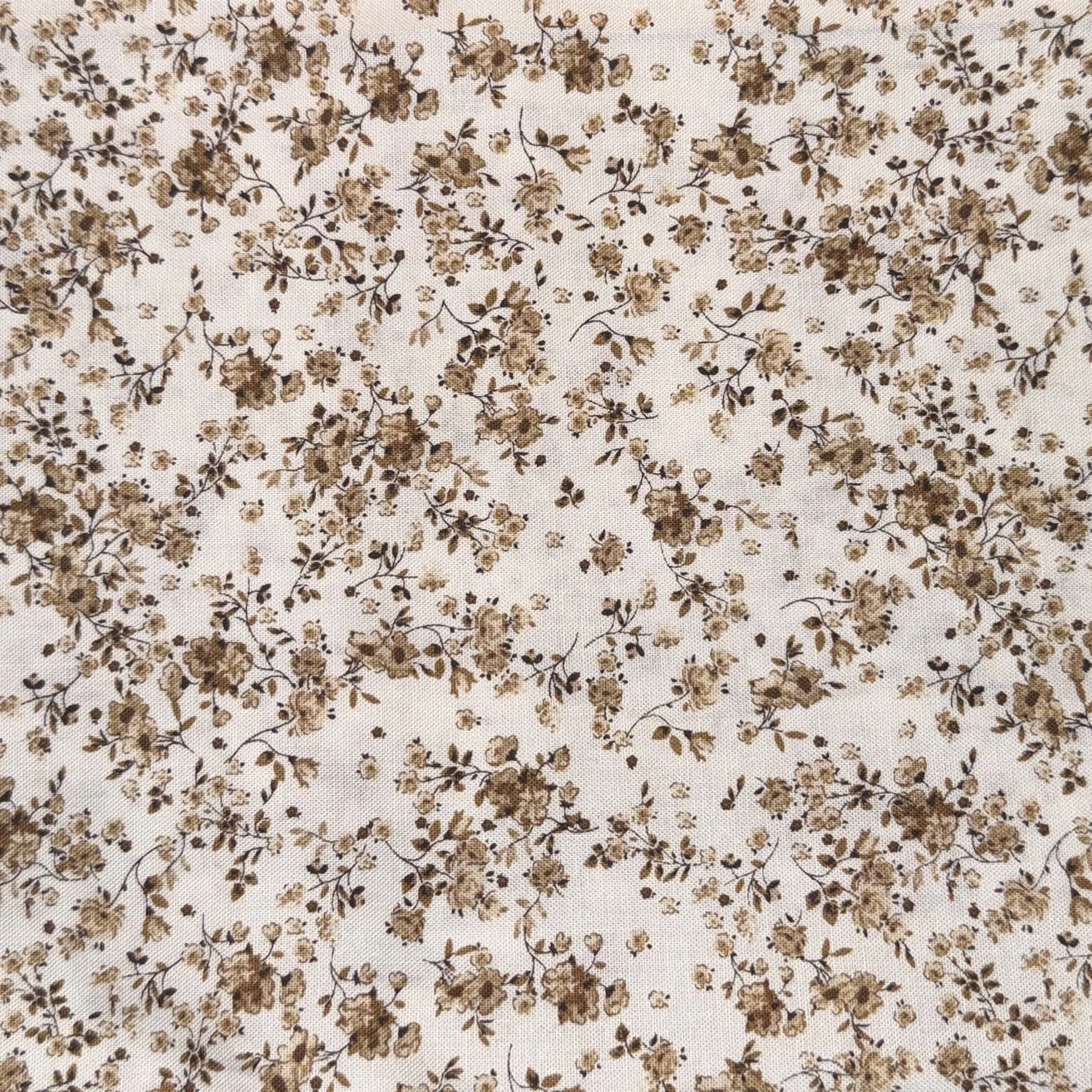 A fabric with a small, dense floral print pattern in shades of brown on a white background.