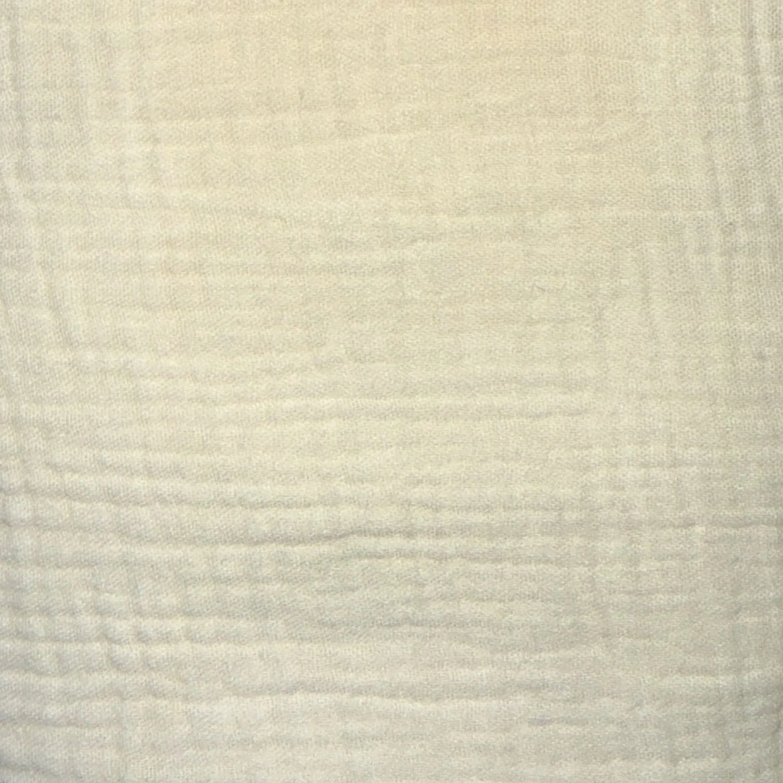 Close-up view of a textured beige fabric surface.