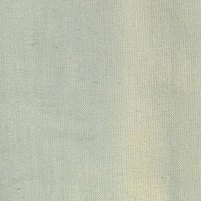 Close-up of a light-colored fabric surface with a tight weave pattern.