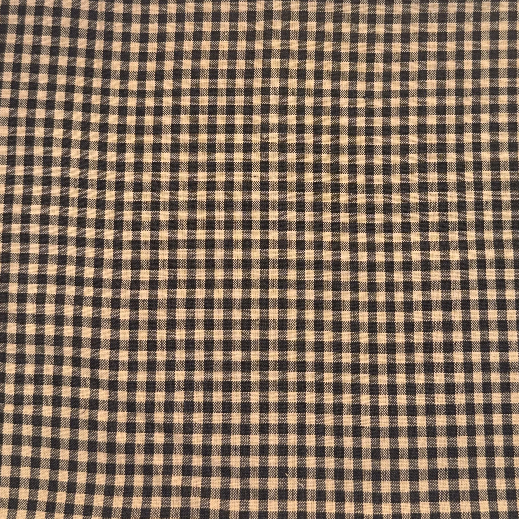 Close-up of a fabric with a black and beige checkered pattern.