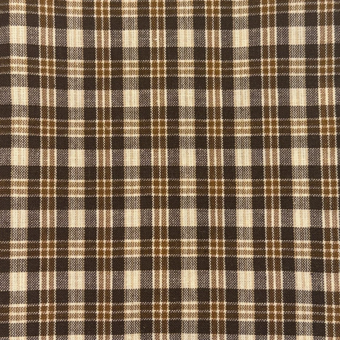 Close-up of a brown, beige, and white plaid fabric pattern.