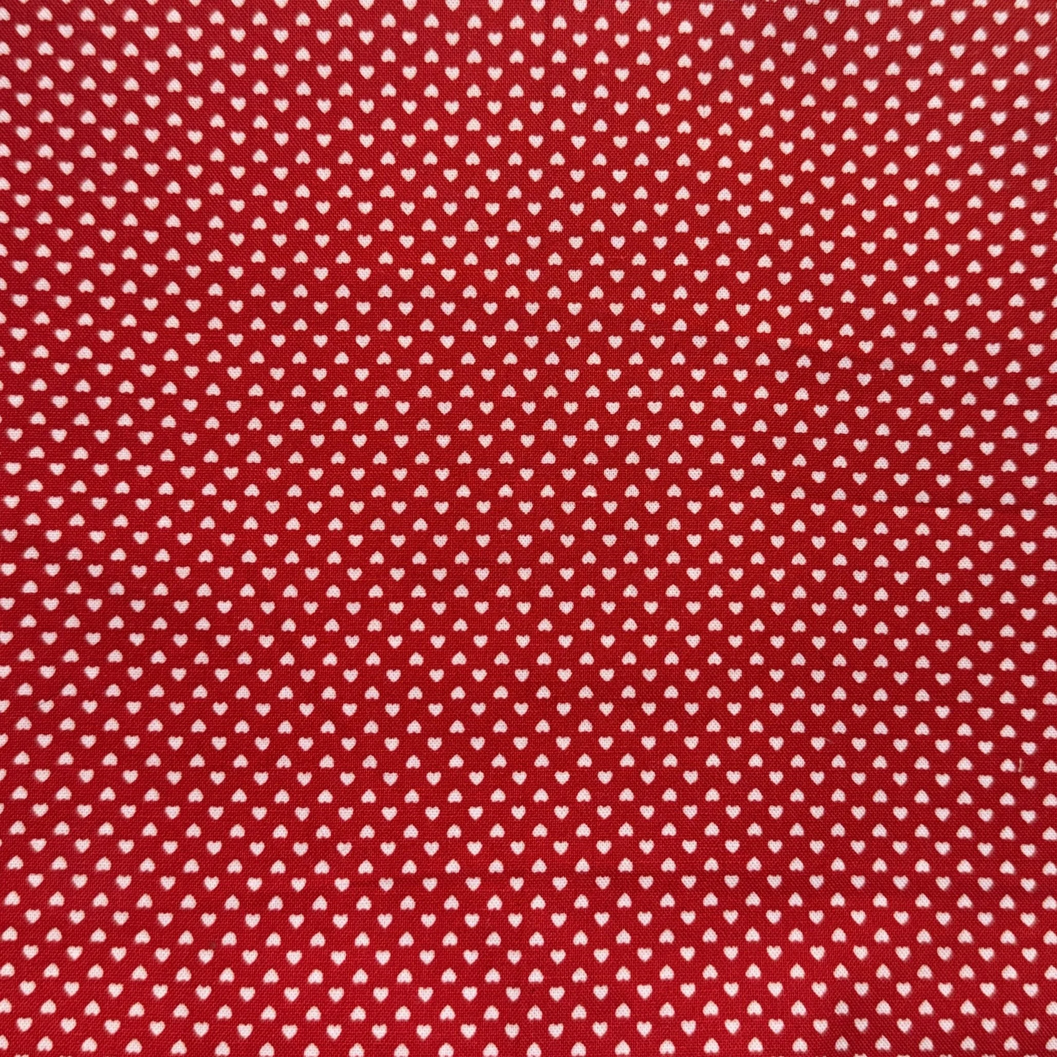 Red fabric with small white heart pattern.