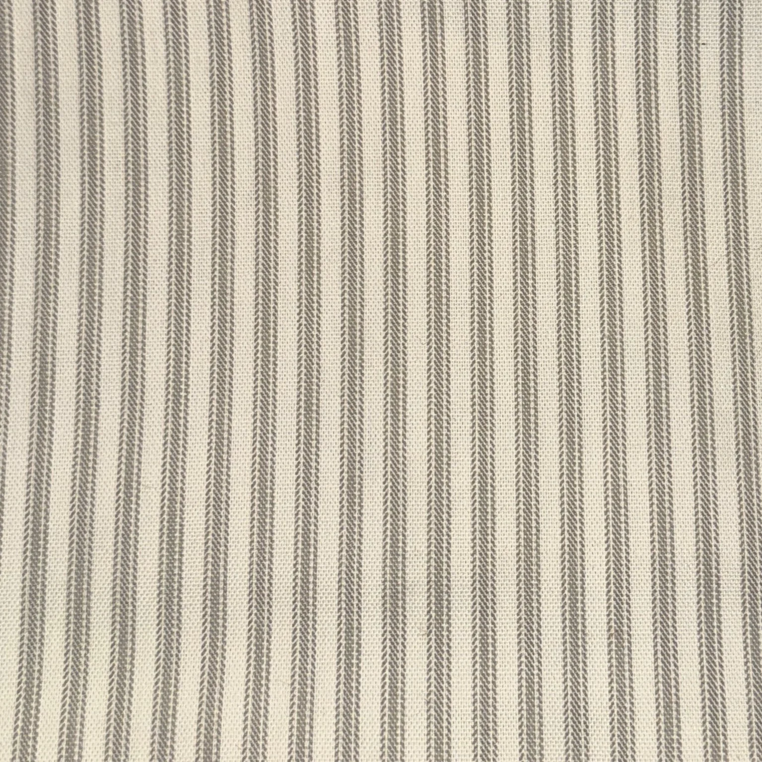 Close-up of a beige fabric with vertical brown striped pattern and herringbone design.