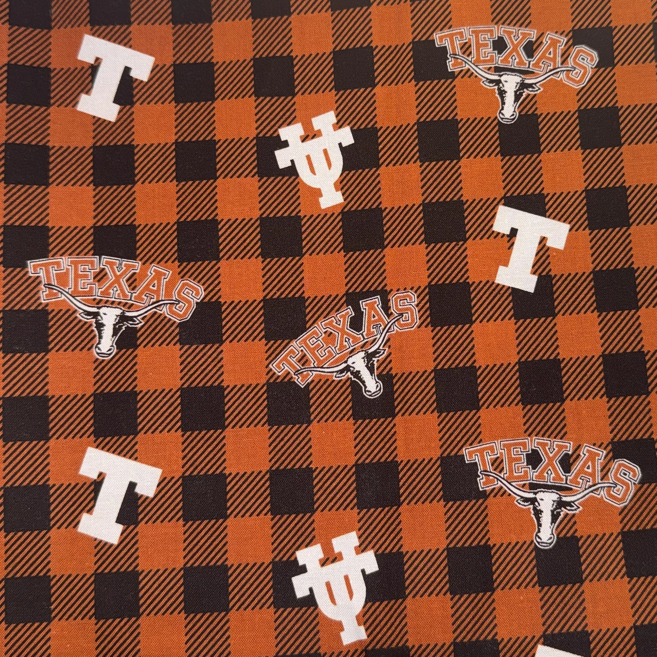 Orange and black plaid pattern with Texas Longhorn logos, white letters T, I, and U scattered across the fabric.