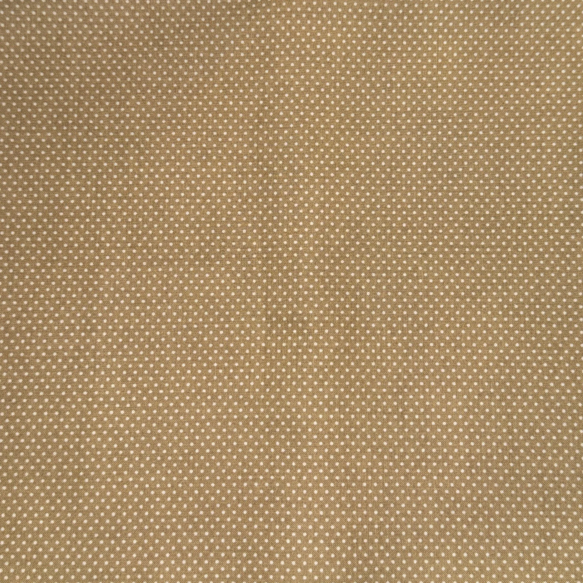 Close-up of tan fabric with small white polka dots.