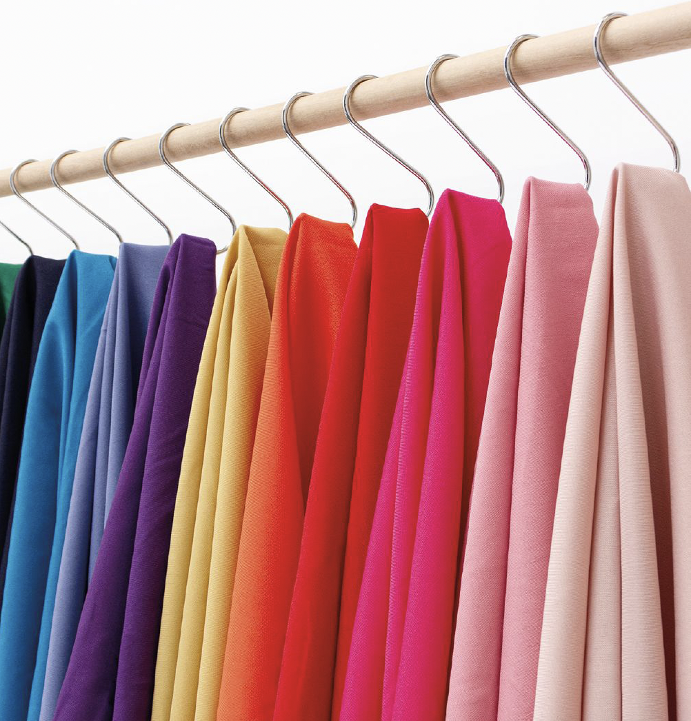 Colorful drapes on hangers representing seasonal color palette options identified through personal color consultation in Fairfax VA