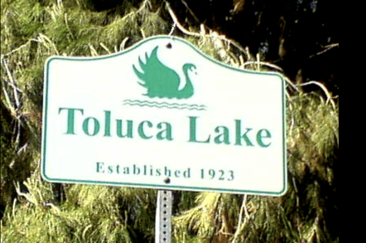 Sign for Toluca Lake with a swan illustration, established in 1923.