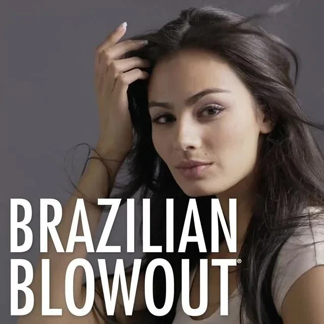 A young woman with long dark hair and a neutral expression, touching her hair against a solid gray background, with the text 'Brazilian Blowout' overlaid on the lower part of the image.