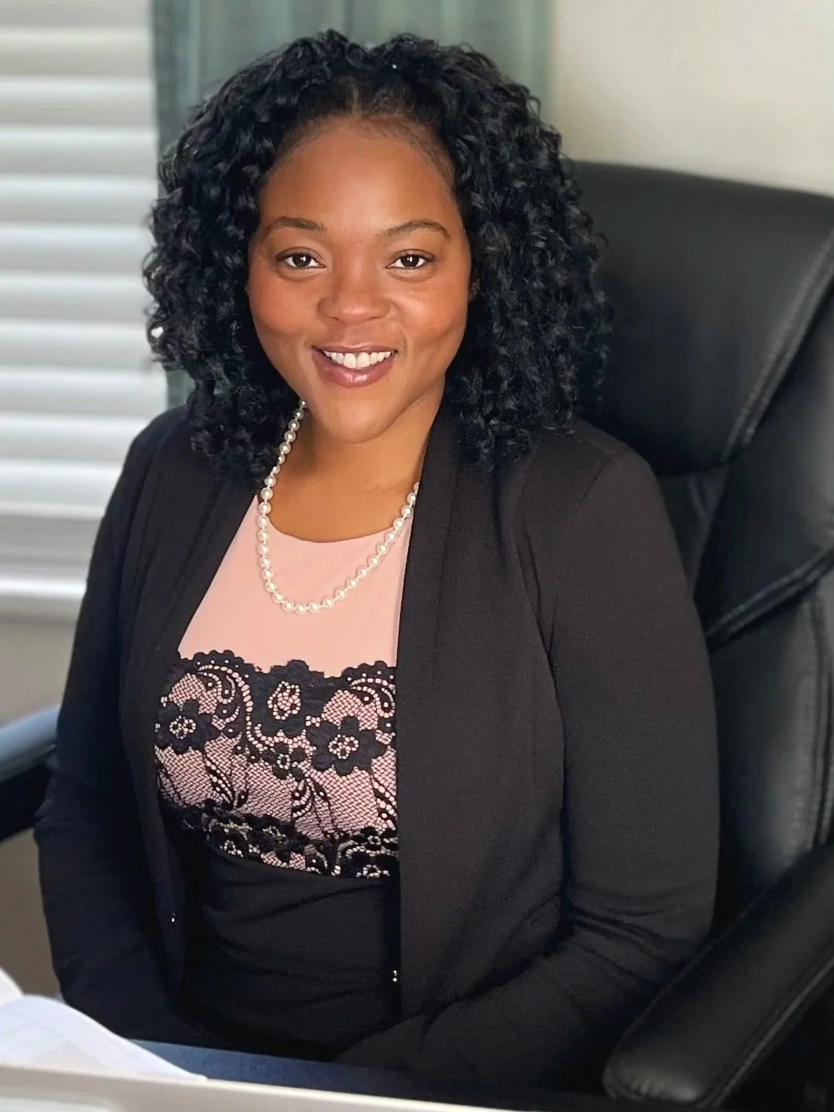 sheenayvonne sitting in a chair wearing black and pink .