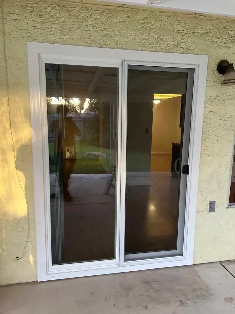New white vinyl sliding glass door installation connecting a home's interior living space to the backyard patio in Stockton, California.