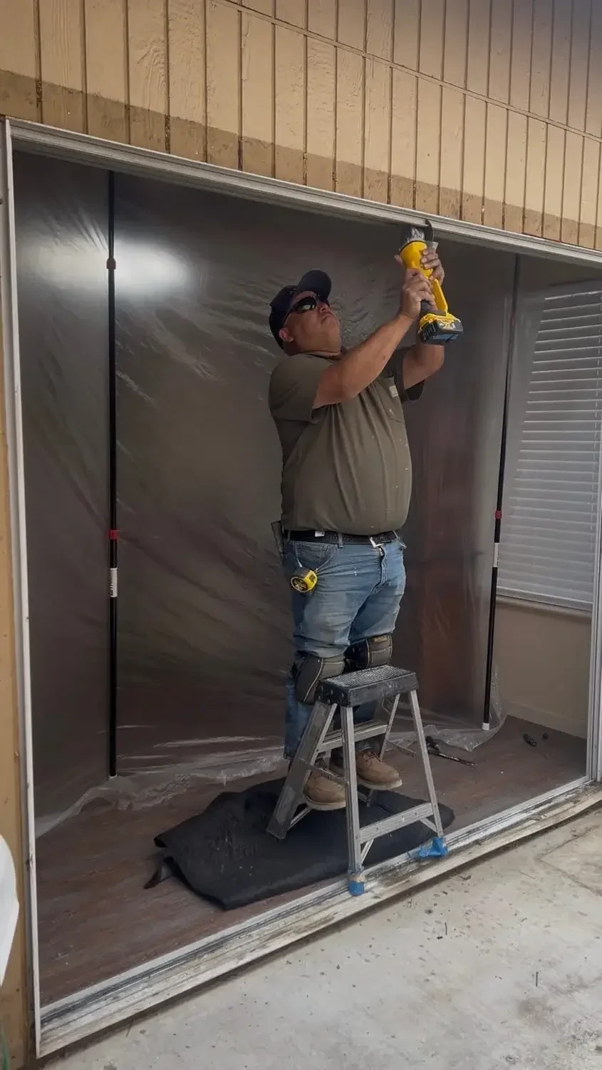 Professional sliding glass door installation in progress with contractor preparing and fitting a new patio door opening.