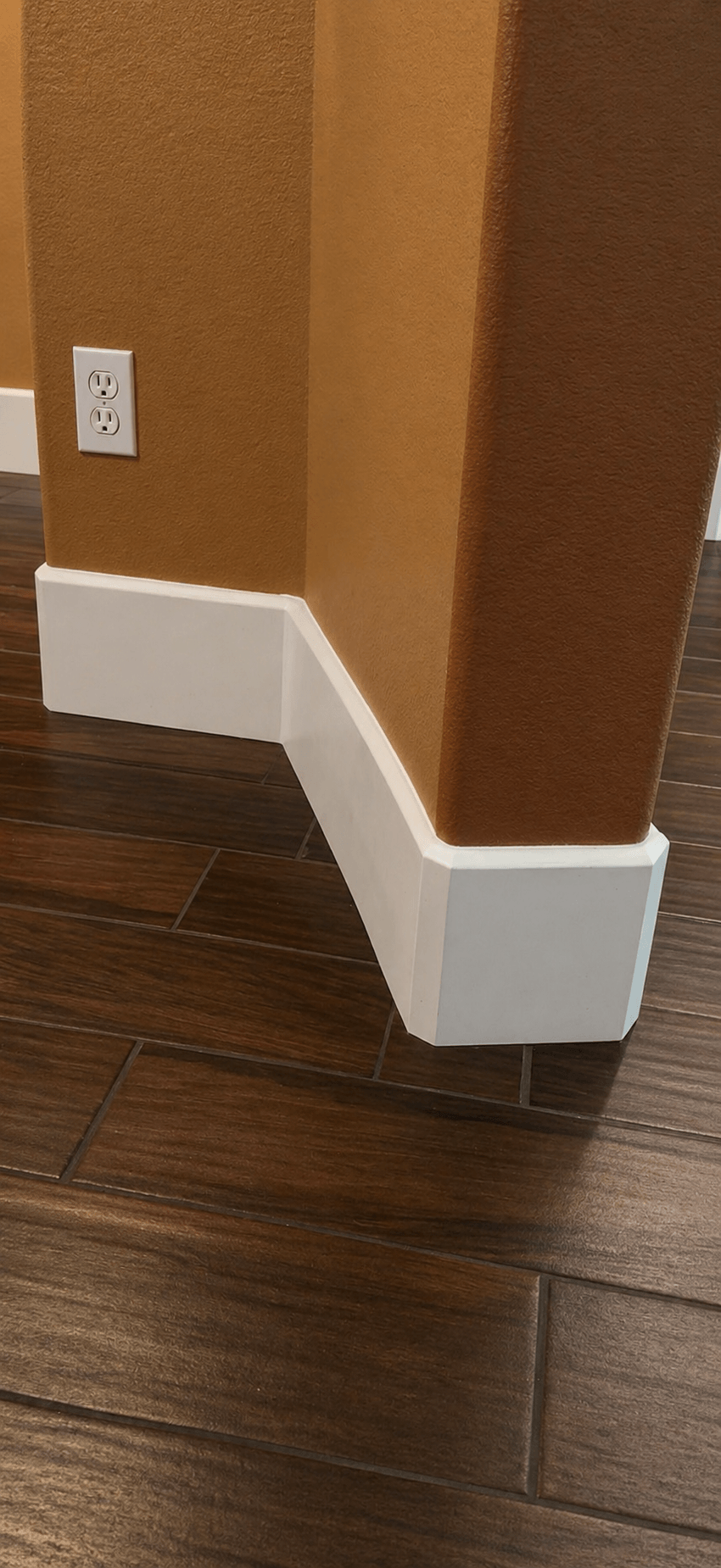 Modern white baseboard installation with clean mitered corners and professional finish in a residential home.