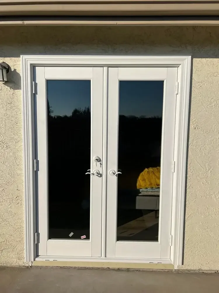 White exterior French door installation with full glass panels on a residential home in Stockton, California.