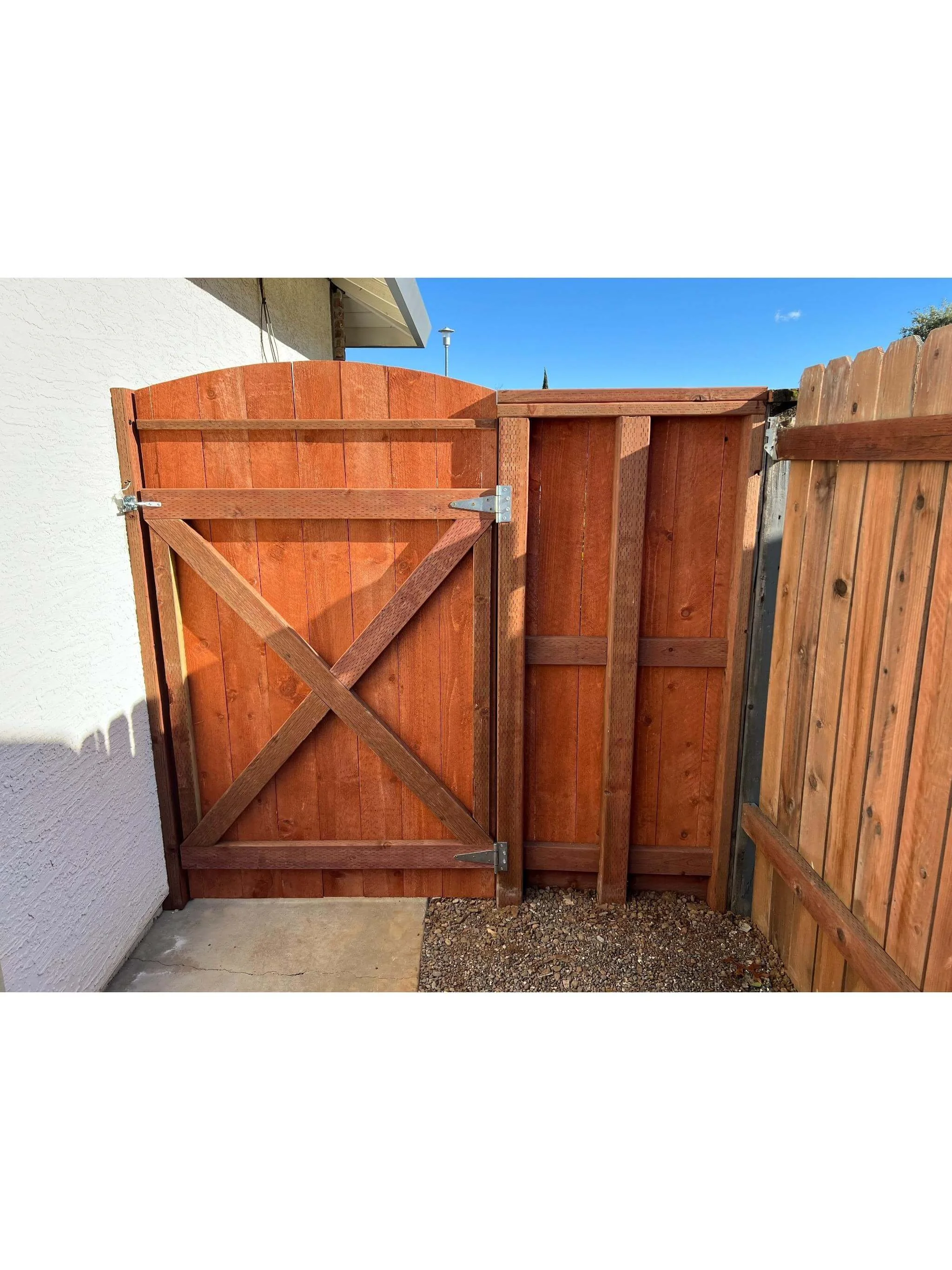 Custom redwood fence gate installation with matching privacy fence and heavy-duty hardware in Stockton, California.