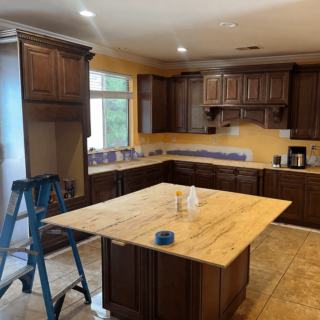 Custom kitchen cabinet installation with crown molding, decorative range hood, and center island in Stockton, California