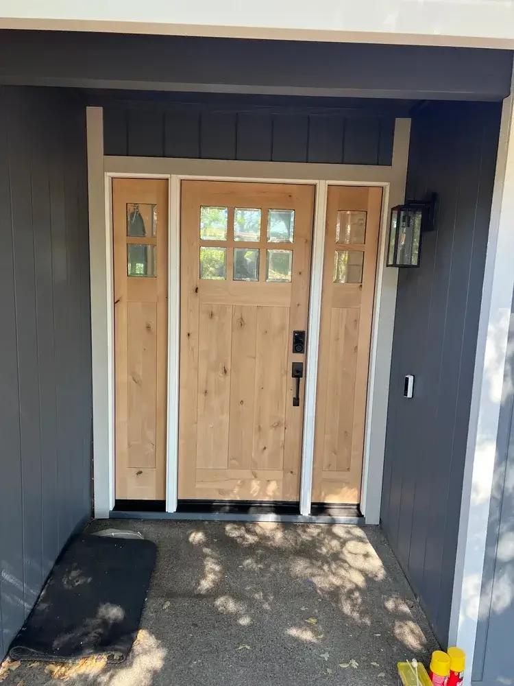 Custom Craftsman-style wood entry door with sidelights professionally installed on a residential home in Stockton, California.