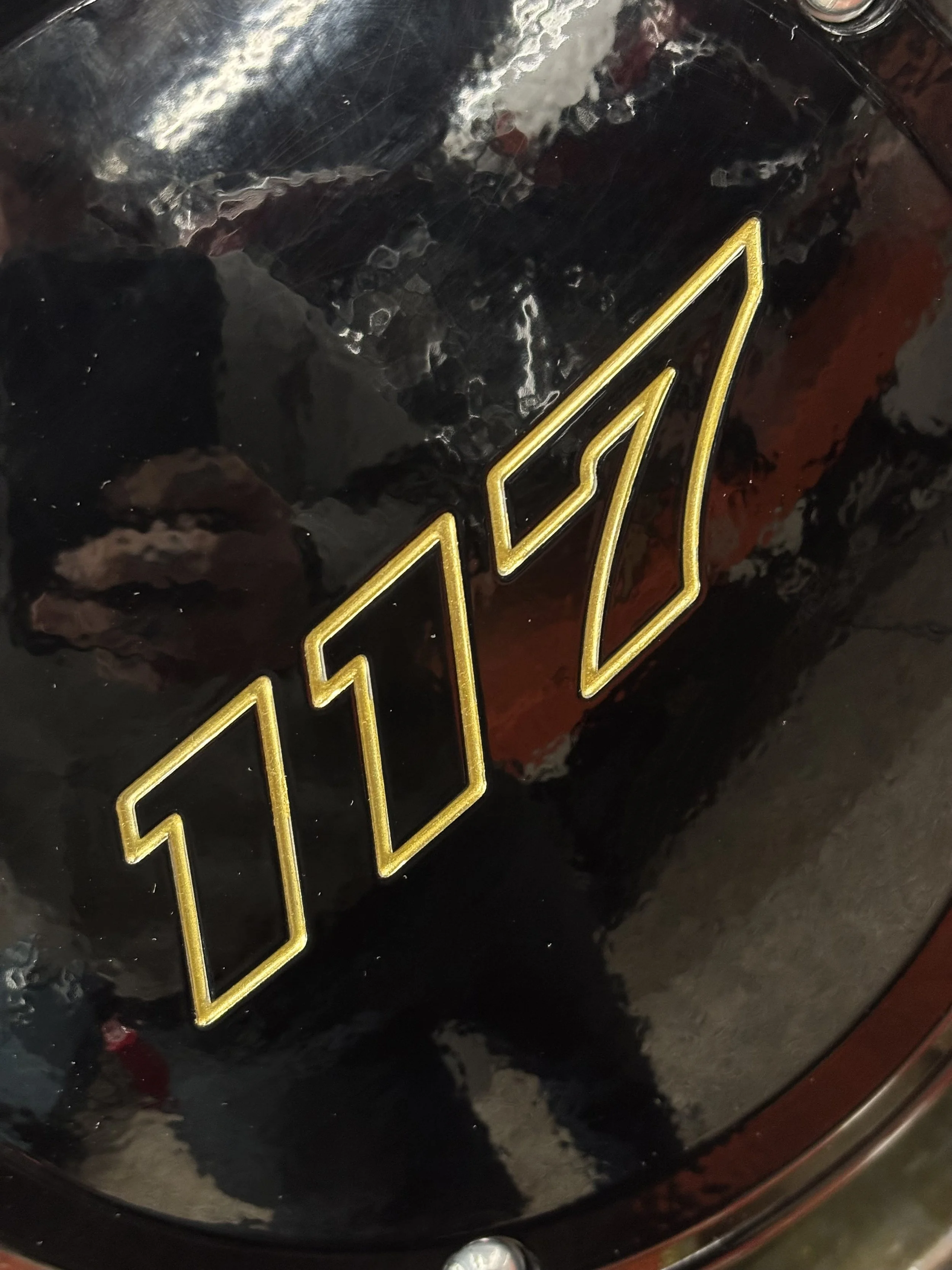Close-up of a black shiny object with the number '1017' outlined in gold.