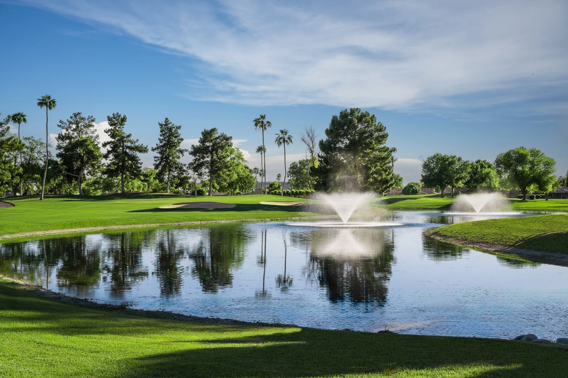 View of the 14th hole at Union Hills Golf Club in Sun City, Arizona, showing a water fountain.
