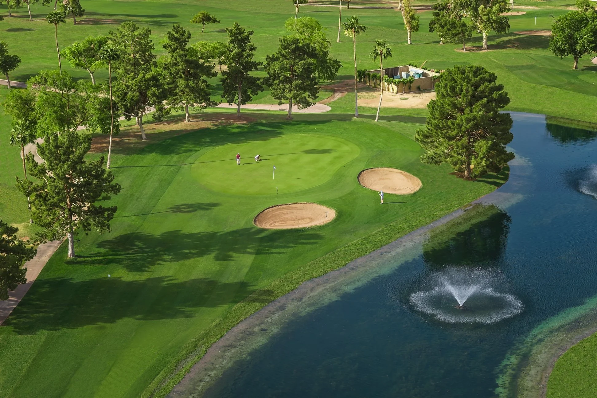 An aerial view Union Hills Golf Club in Sun City, Arizona, showing a fairway, putting green, sand bunkers and a water feature.