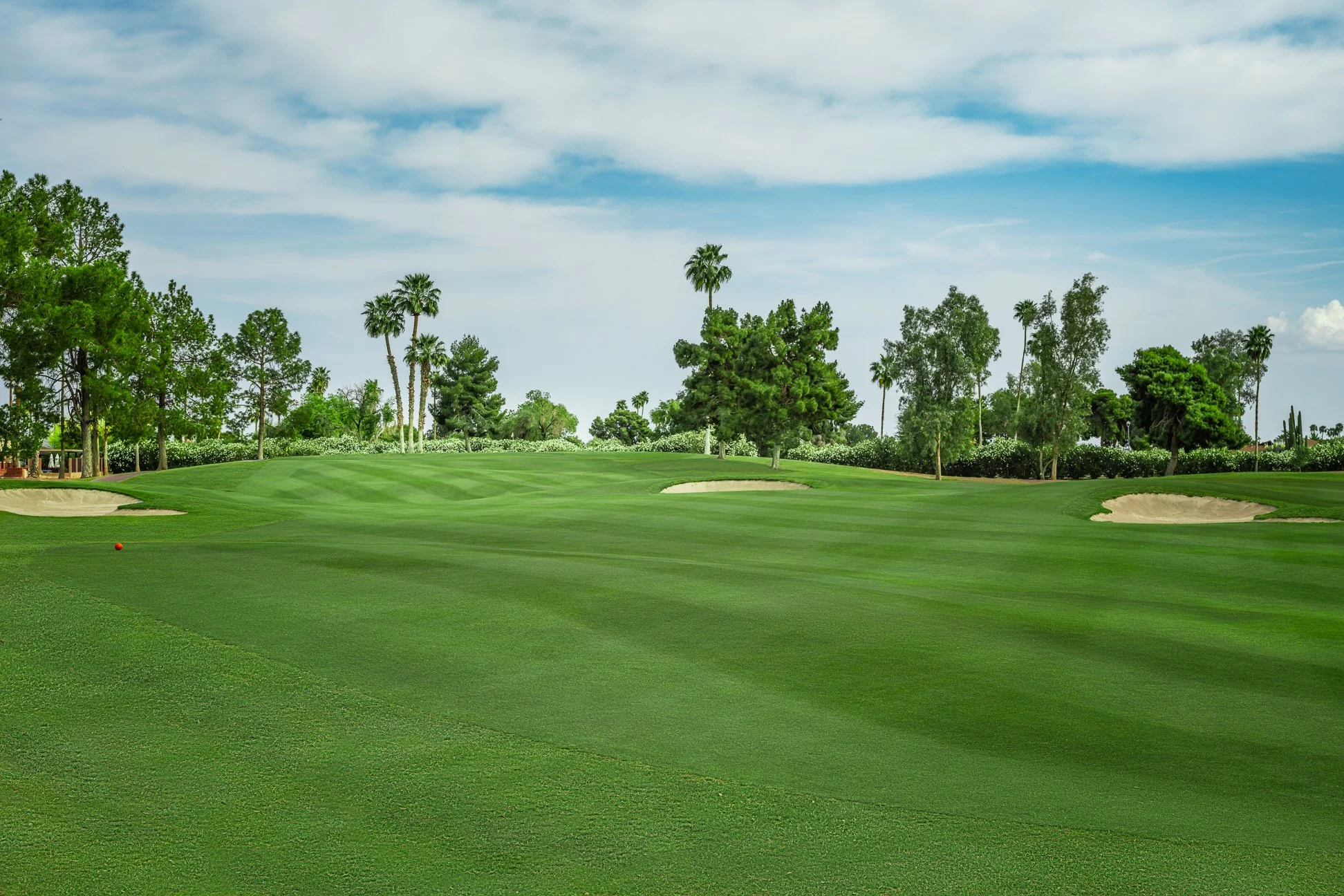 View of a lush green fairway on the 13th hole of the golf course at Briarwood Country Club in Sun City West Arizona.