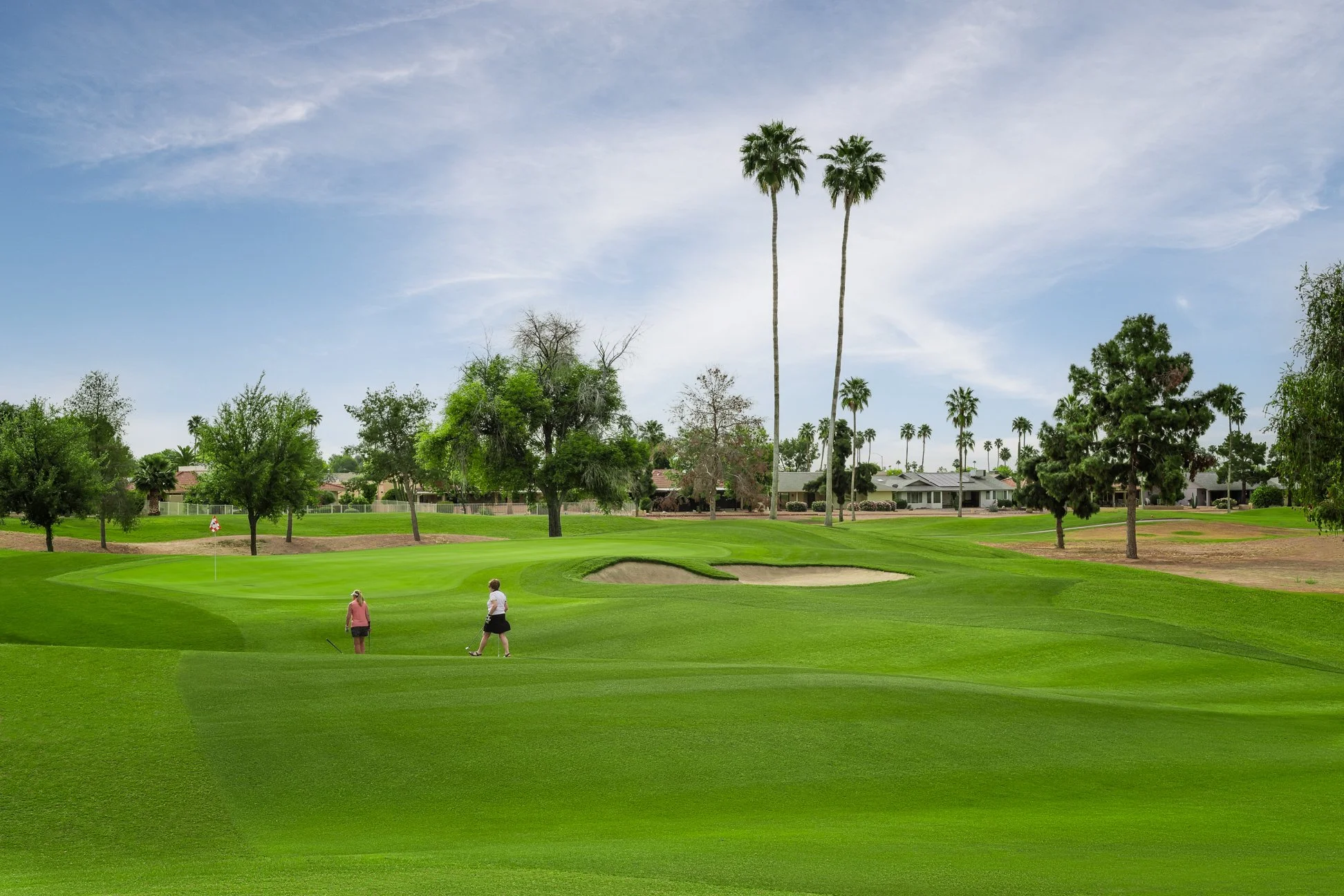 View from the fairway of the 6th hole on the golf course at Briarwood Country Club in Sun City West Arizona with men on the course.