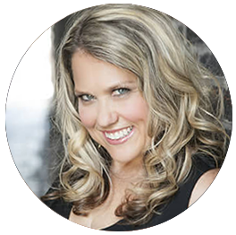 A smiling woman with blonde wavy hair wearing a black top