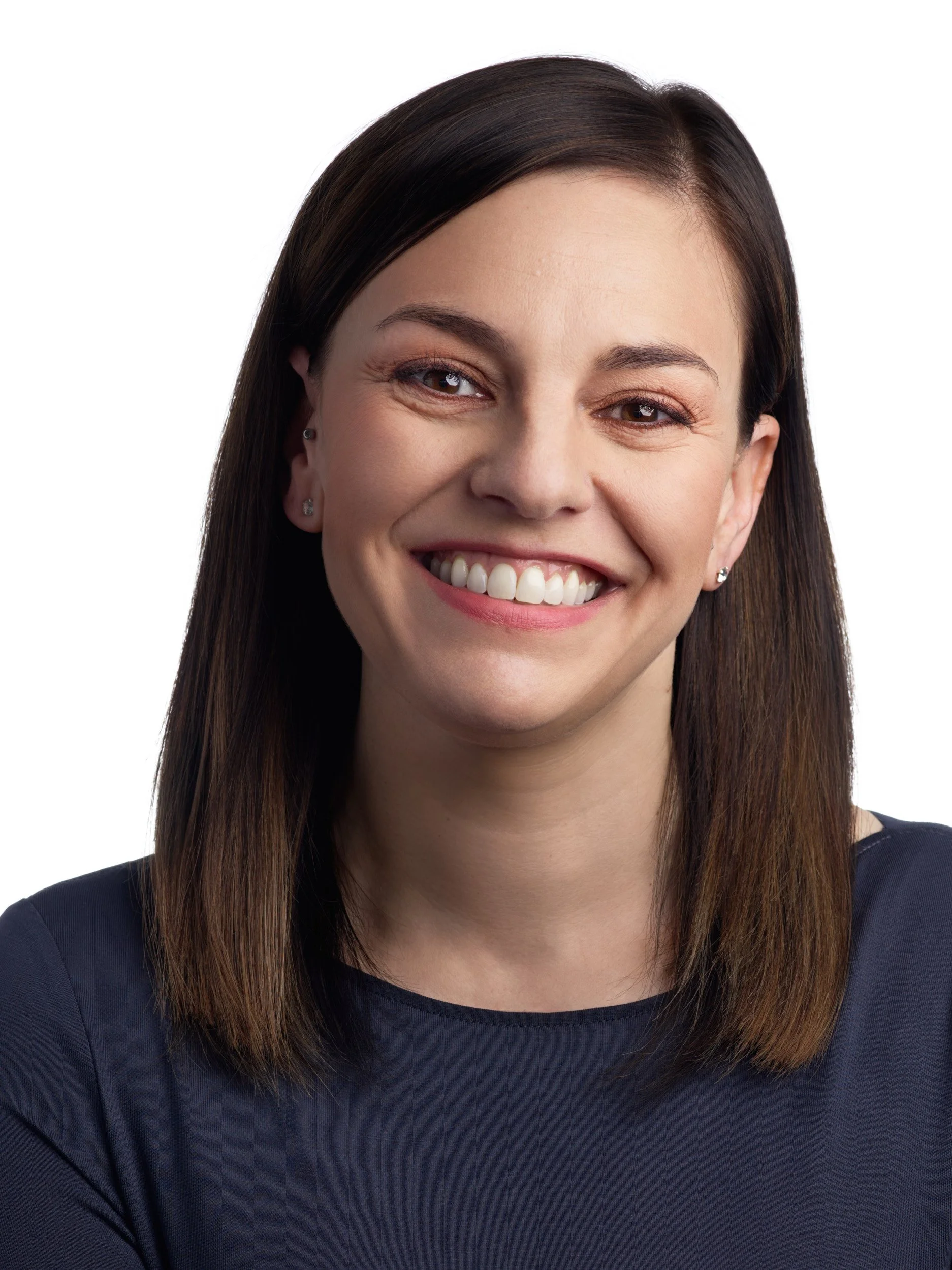 Close-up of a smiling woman with straight brown hair wearing a navy blue top, white background.