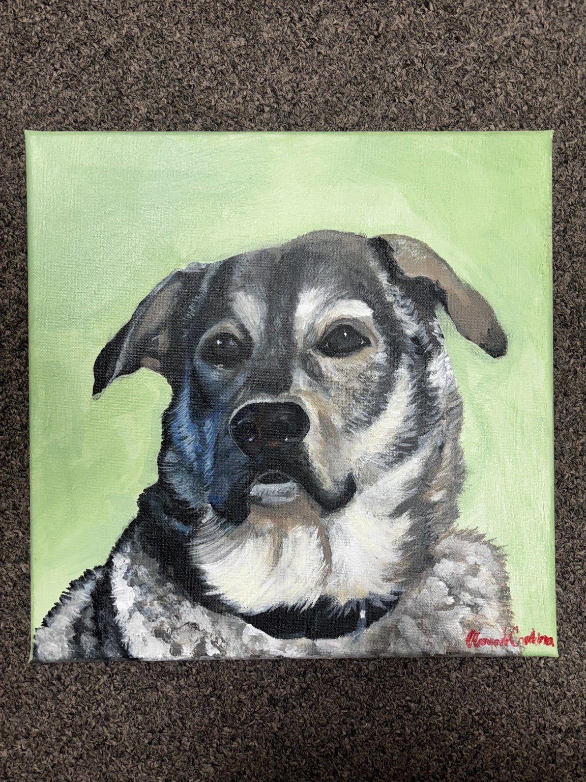 Painting of a dog with a green background, signed in red at the bottom right corner.