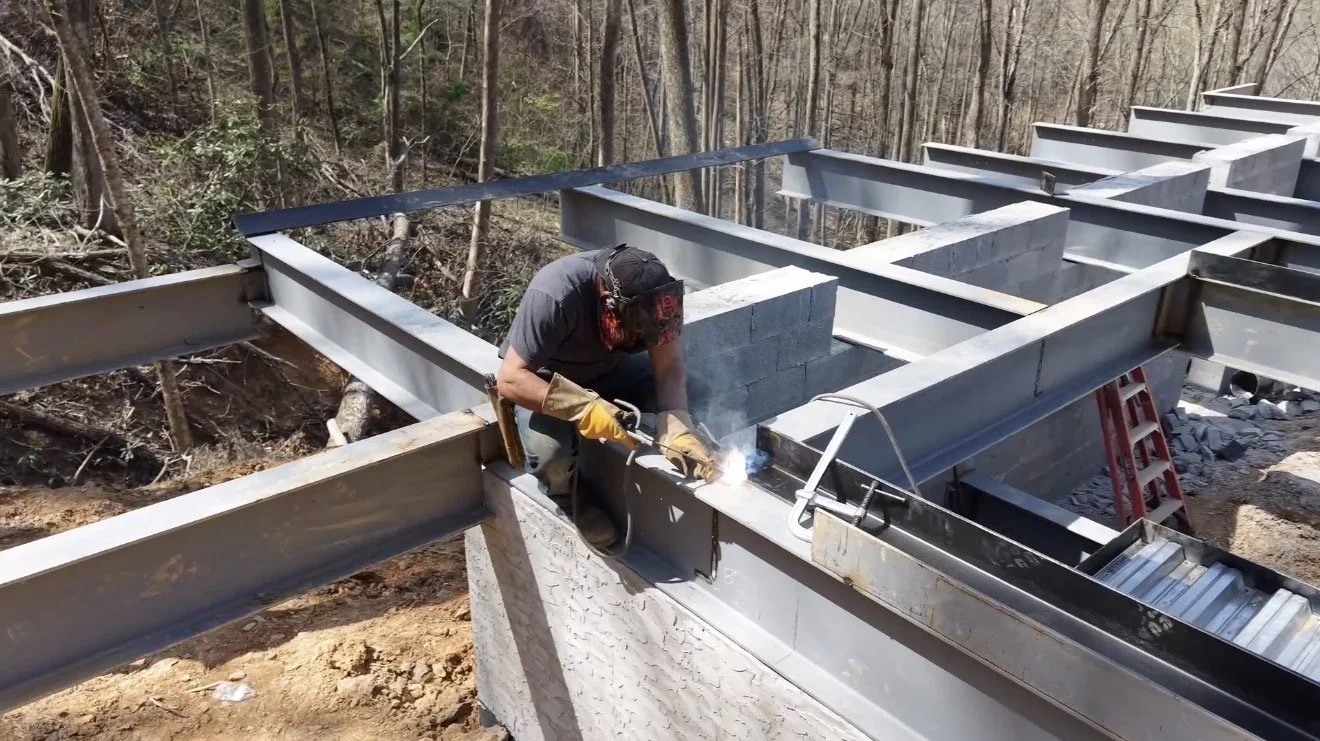 Welding steel beams during foundation and structural construction in East Tennessee.
