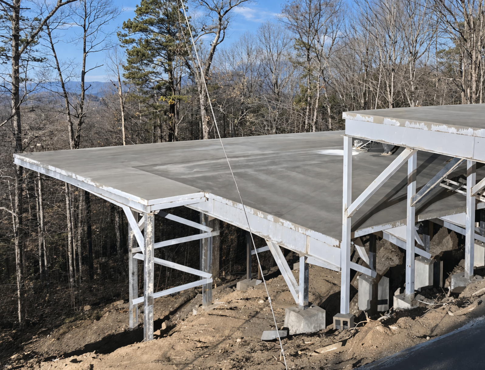 Elevated concrete slab on steel supports in East Tennessee hillside construction project.