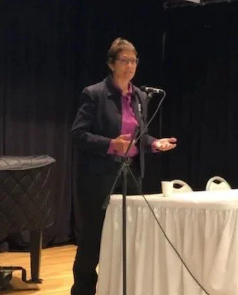 Marcia on stage speaking at event