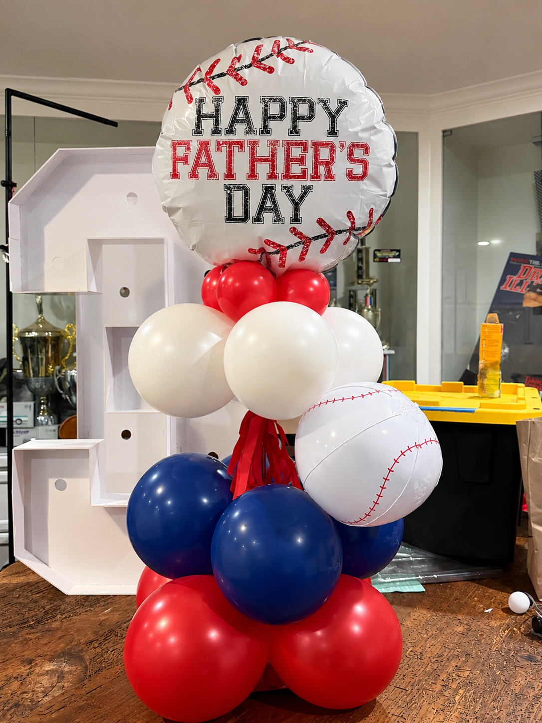 Father’s Day Balloon Table Centerpiece featuring a stylish arrangement of blue, red, and white balloons. Perfect for Father’s Day brunches, family gatherings, office celebrations, and special events. This custom balloon centerpiece adds a festive tou