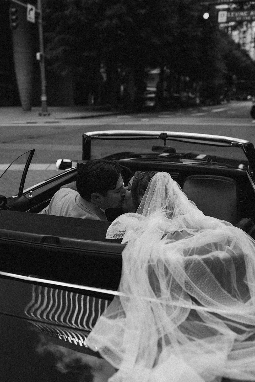 Black and white image of bride and groom leaving reception