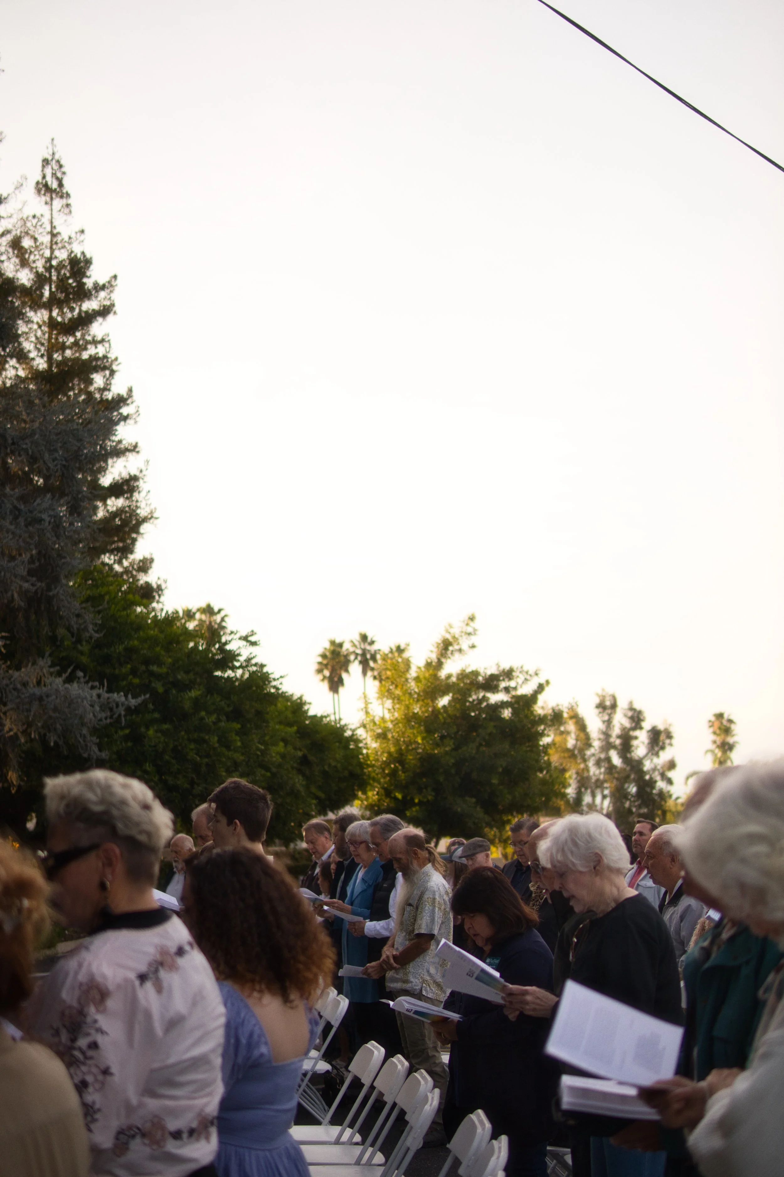 A large group of people gathered outdoors, participating in the church's sunrise Easter service.