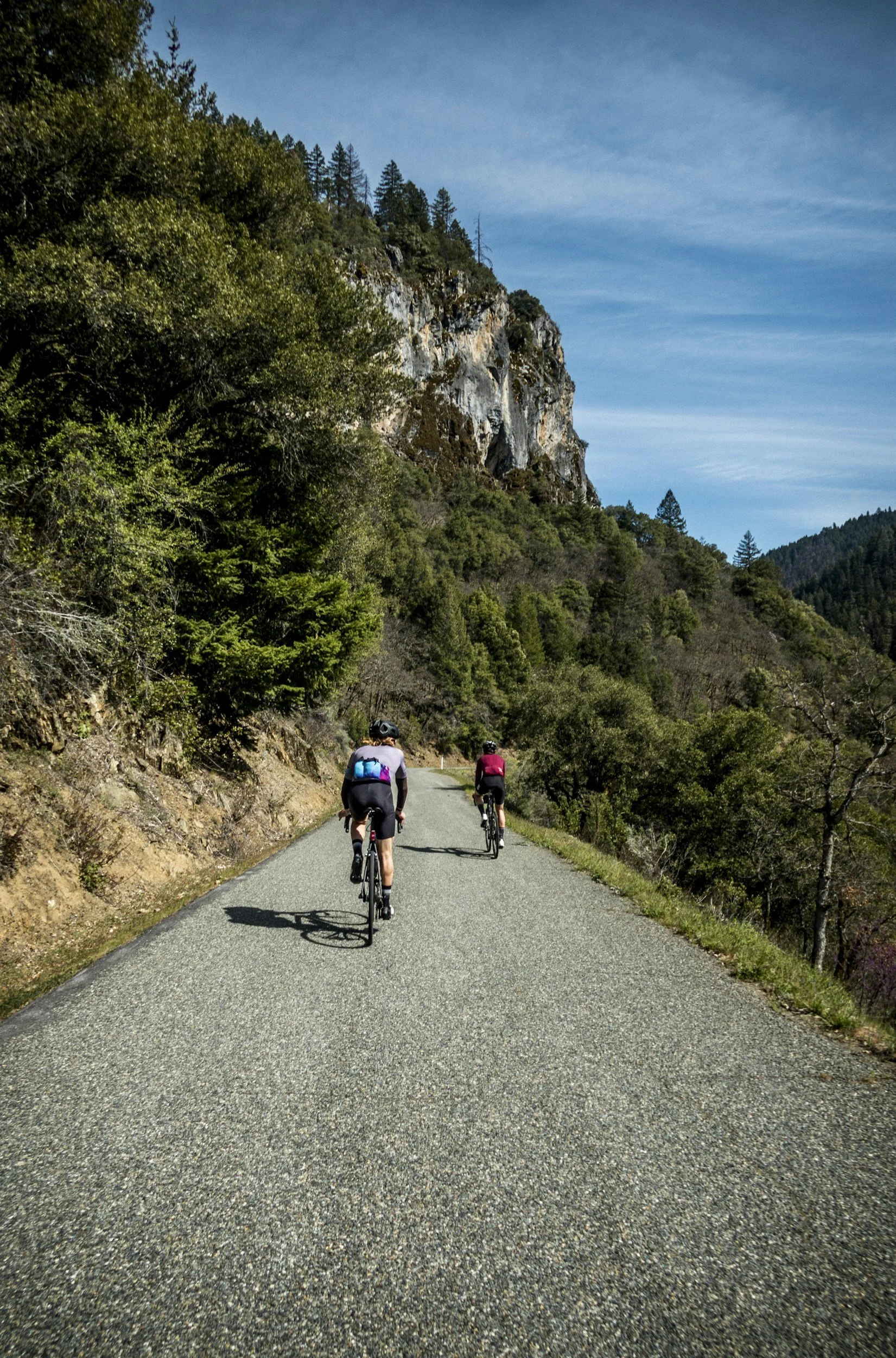 two bike riders climbing up a mountain pass